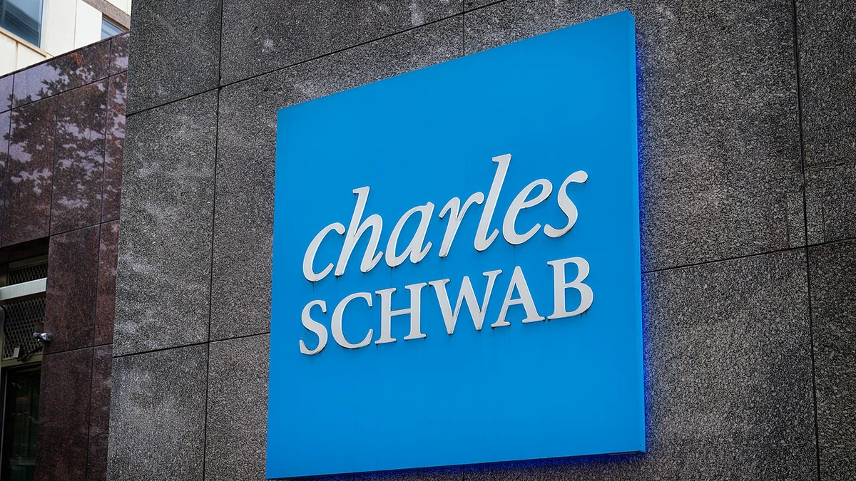 Large blue Charles Schwab sign mounted on the facade of an office building in Bethesda, Maryland.