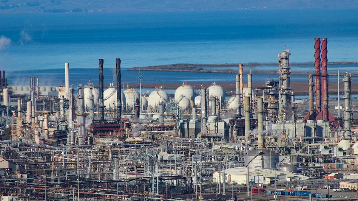 Chevron's Richmond refinery with processing equipment and storage tanks in front of San Pablo Bay in California.