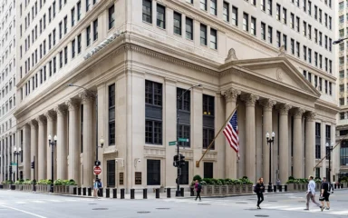 Exterior of the Federal Reserve Bank of Chicago building, with columns and an American flag.