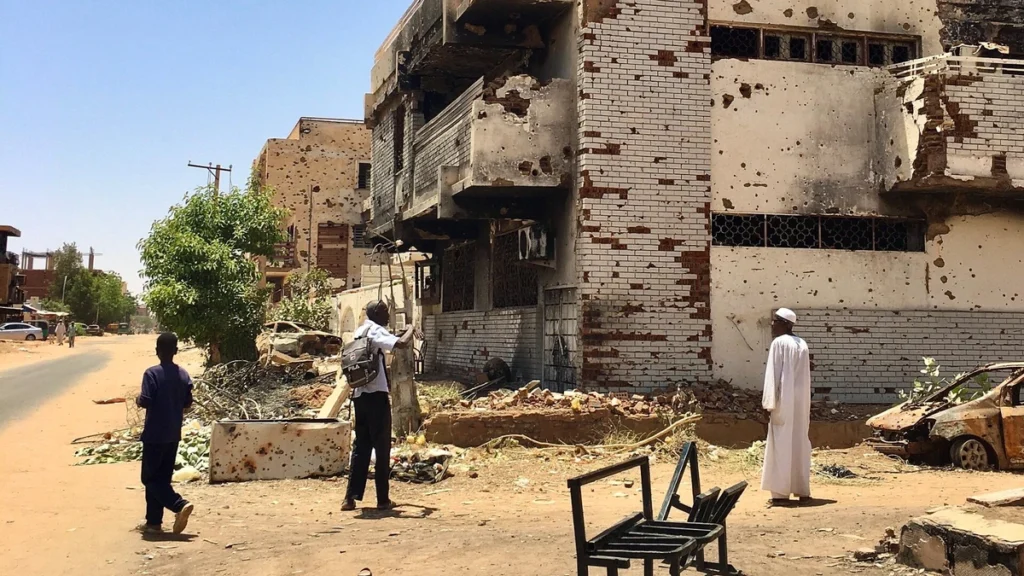 Damaged multi-storey building with scarred walls and exposed brickwork in the Wad Nubawi neighborhood of Omdurman, Sudan.