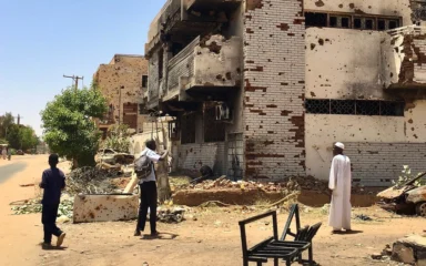 Damaged multi-storey building with scarred walls and exposed brickwork in the Wad Nubawi neighborhood of Omdurman, Sudan.