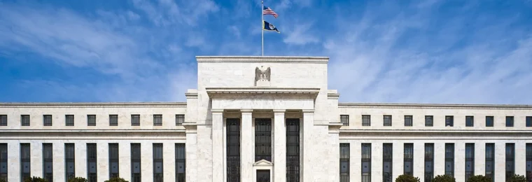 Front of the Federal Reserve Board's Marriner S. Eccles Building in Washington, D.C., under a blue sky.
