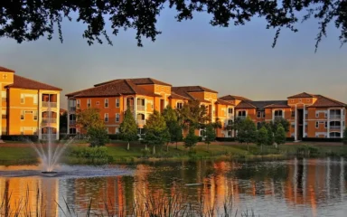 Apartment buildings at the La Palazza complex in MetroWest, Orlando, Florida, reflected in a pond at sunset.