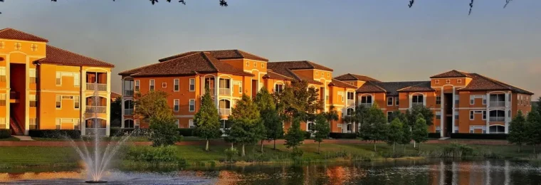 Apartment buildings at the La Palazza complex in MetroWest, Orlando, Florida, reflected in a pond at sunset.