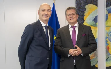 Roland Lescure, at left, and Maroš Šefčovič standing near a European Union flag in Brussels.