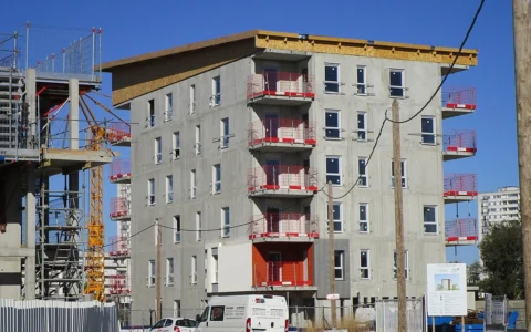 A 22-apartment social-housing building under construction with adjacent scaffolding in Tours, France.