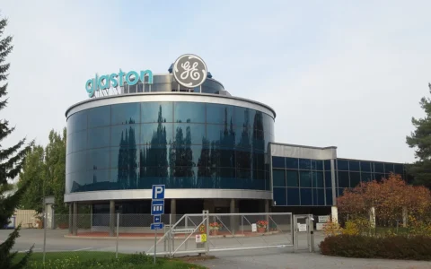 Glass-fronted GE Grid Solutions facility in Tampere, Finland, with GE and Alstom signage.