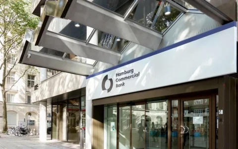 Entrance to Hamburg Commercial Bank in Hamburg, Germany, with its name and logo displayed above the doors.