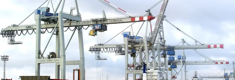 Container ships moored beneath large loading cranes at Container Terminal Tollerort in the Port of Hamburg, Germany.