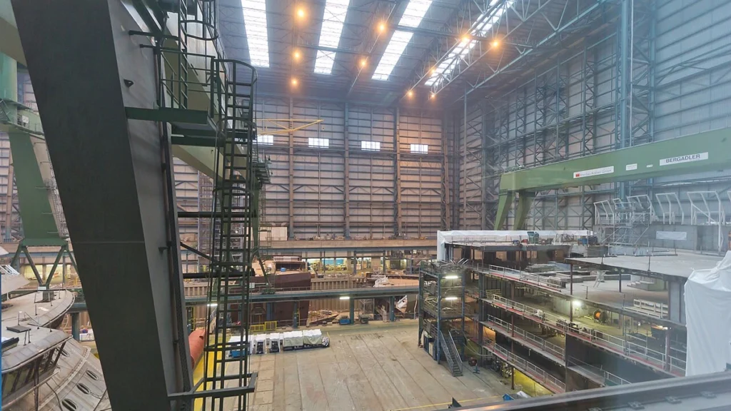 Interior of the Meyer Werft shipyard in Papenburg, Germany, with shipbuilding structures and industrial equipment.