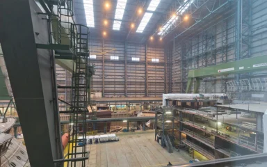 Interior of the Meyer Werft shipyard in Papenburg, Germany, with shipbuilding structures and industrial equipment.