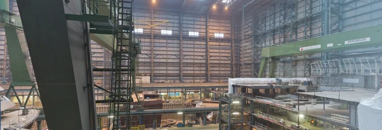 Interior of the Meyer Werft shipyard in Papenburg, Germany, with shipbuilding structures and industrial equipment.