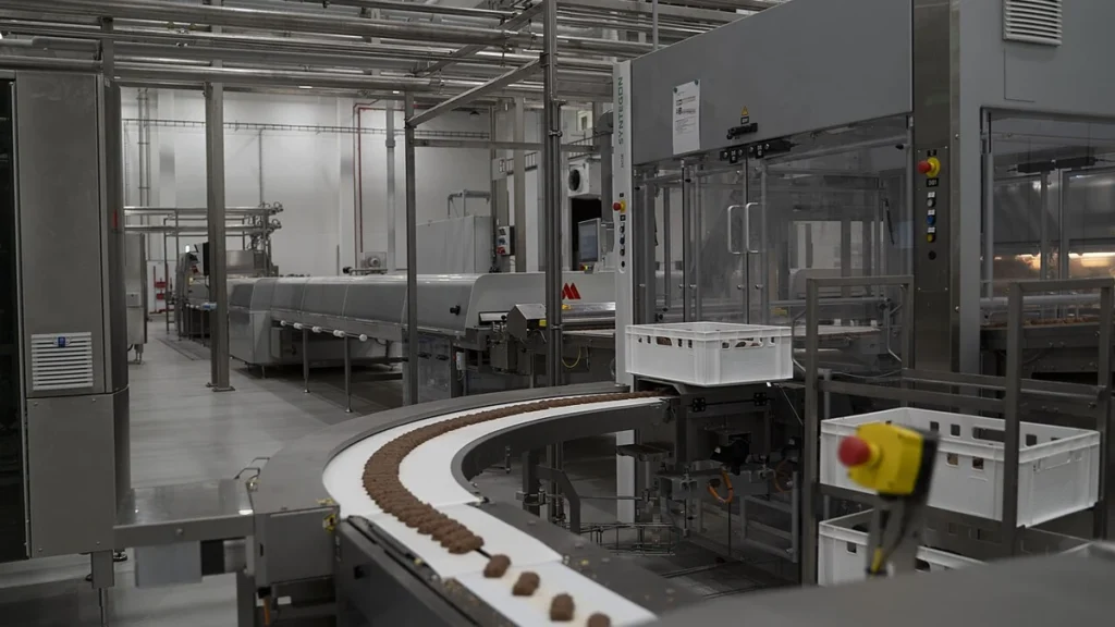 Production machinery and conveyor belt inside The Quality Group's facility in Elmshorn, Germany.