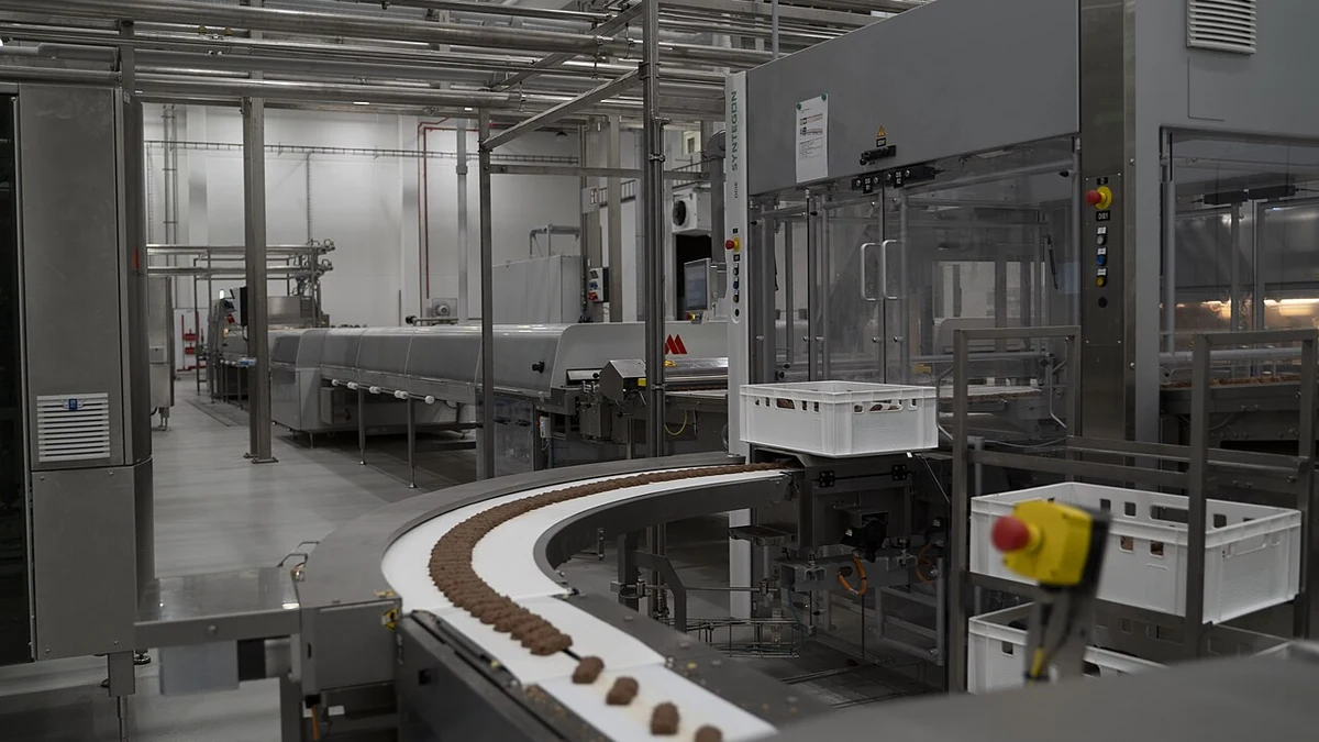 Production machinery and conveyor belt inside The Quality Group's facility in Elmshorn, Germany.