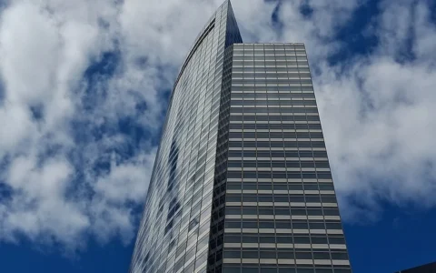 Goldman Sachs headquarters at 200 West Street in New York, photographed from street level against a cloudy sky.