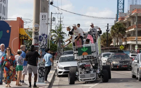 Instacart-branded vehicle on a Miami street with several people riding on it in July 2022.