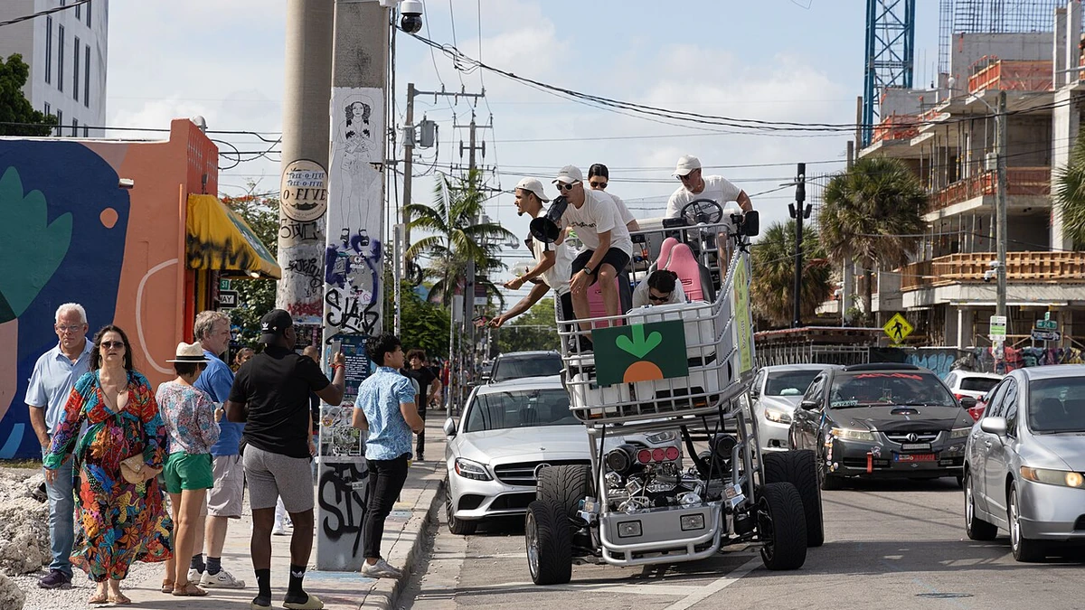 Instacart-branded vehicle on a Miami street with several people riding on it in July 2022.