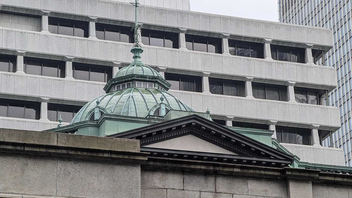 Bank of Japan building in Tokyo with its green copper dome in front of a modern office building.
