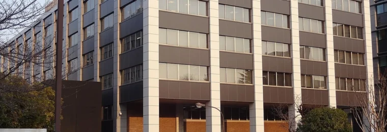 Exterior of Japan’s Cabinet Office building in Tokyo, showing office windows and the main entrance.