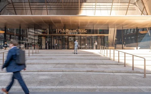 Glass entrance and JPMorgan Chase sign at 270 Park Avenue in New York City, with pedestrians on the steps.