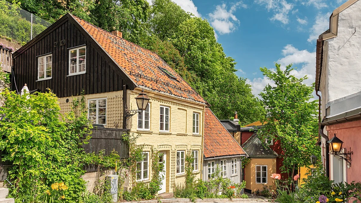 Traditional wooden and painted residential houses along a cobblestone street in Oslo, Norway.