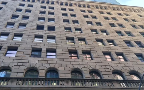Upper facade and rows of windows of the Federal Reserve Bank of New York building in Manhattan.