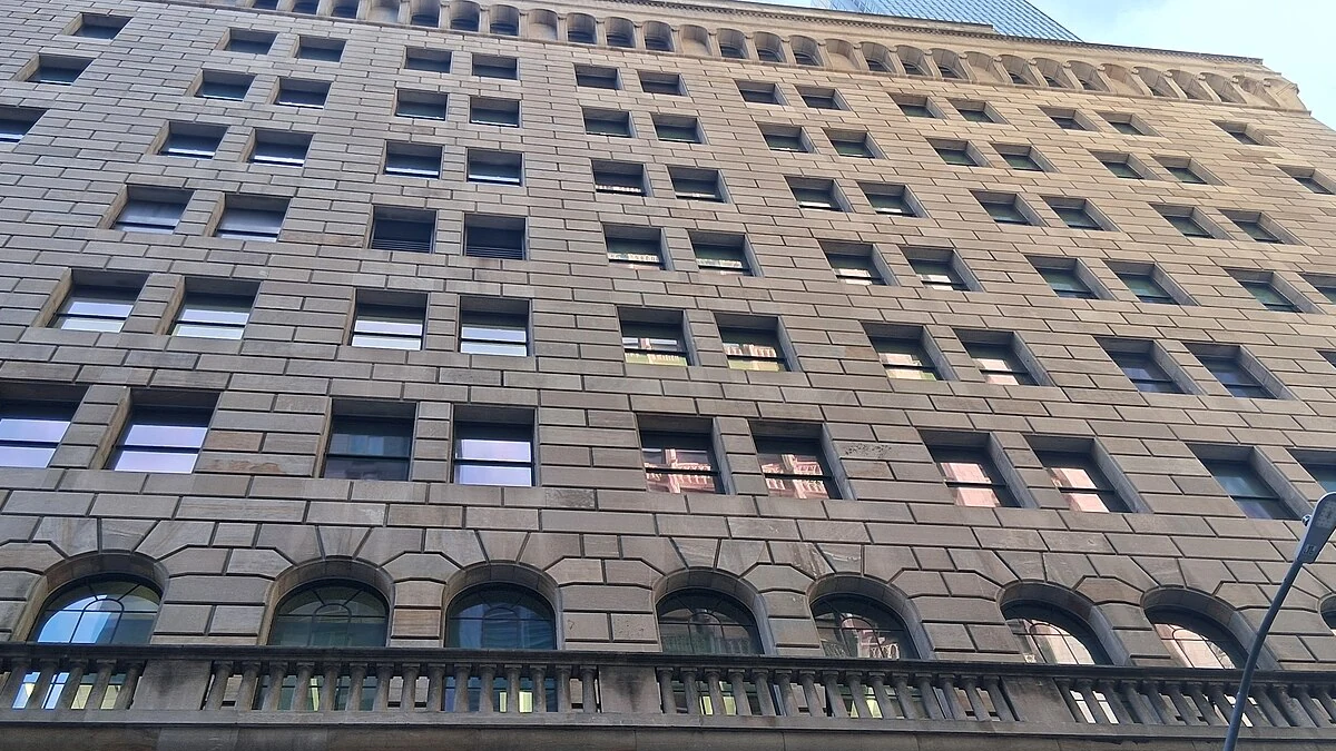 Upper facade and rows of windows of the Federal Reserve Bank of New York building in Manhattan.