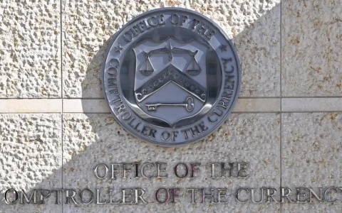 Office of the Comptroller of the Currency seal and lettering on the wall outside its Washington, D.C., headquarters.