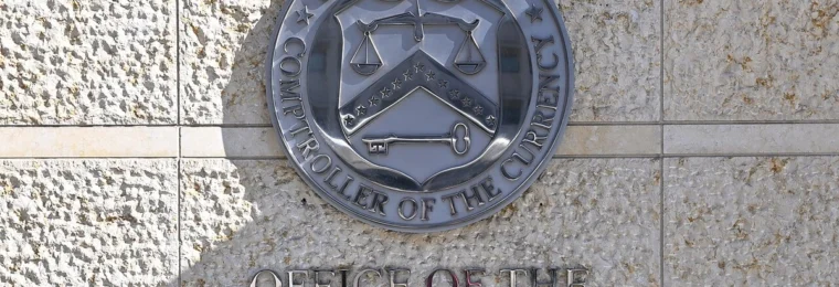 Office of the Comptroller of the Currency seal and lettering on the wall outside its Washington, D.C., headquarters.