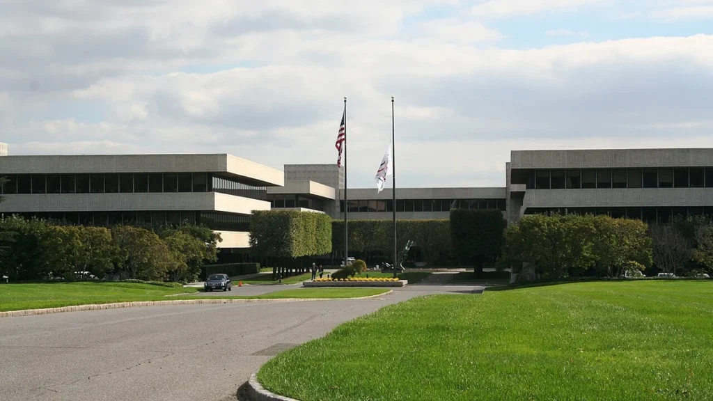 Exterior of PepsiCo’s headquarters complex in Purchase, New York, with flagpoles, a driveway and lawn.