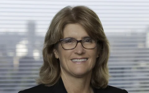 Portrait of Reserve Bank of Australia Governor Michele Bullock wearing glasses and a dark jacket.