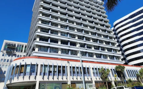 Street-level view of the Reserve Bank of New Zealand building and entrance signage in Wellington.