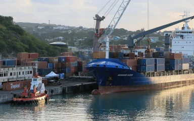 Seaboard Ocean container vessel docked in Antigua beside stacked shipping containers.