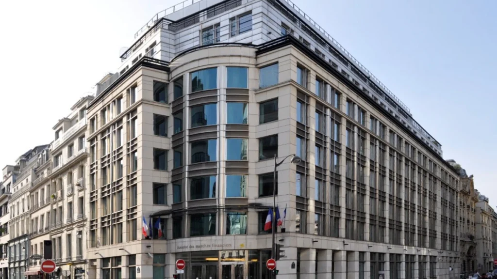 Exterior of the French financial regulator AMF headquarters at 17 Place de la Bourse in Paris, with French and EU flags outside.