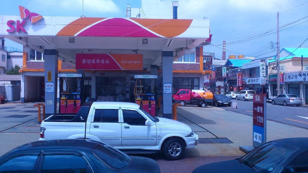An SK gas station in South Korea with vehicles parked near the fuel pumps.