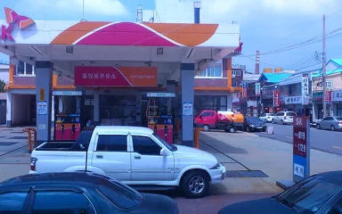An SK gas station in South Korea with vehicles parked near the fuel pumps.