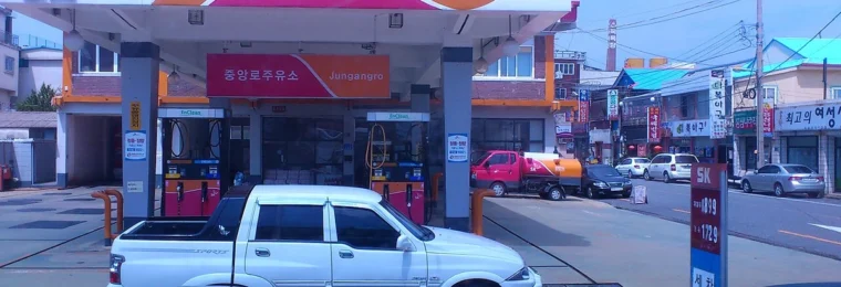 An SK gas station in South Korea with vehicles parked near the fuel pumps.