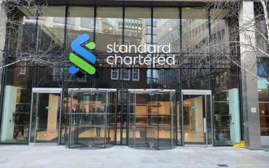 Standard Chartered headquarters entrance in London with the bank's logo above the doors.