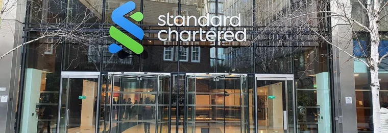 Standard Chartered headquarters entrance in London with the bank's logo above the doors.