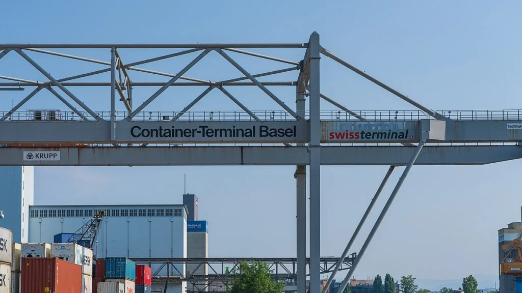 Container gantry crane above stacked freight containers at the Kleinhüningen Rhine port in Basel, Switzerland.