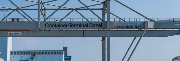 Container gantry crane above stacked freight containers at the Kleinhüningen Rhine port in Basel, Switzerland.