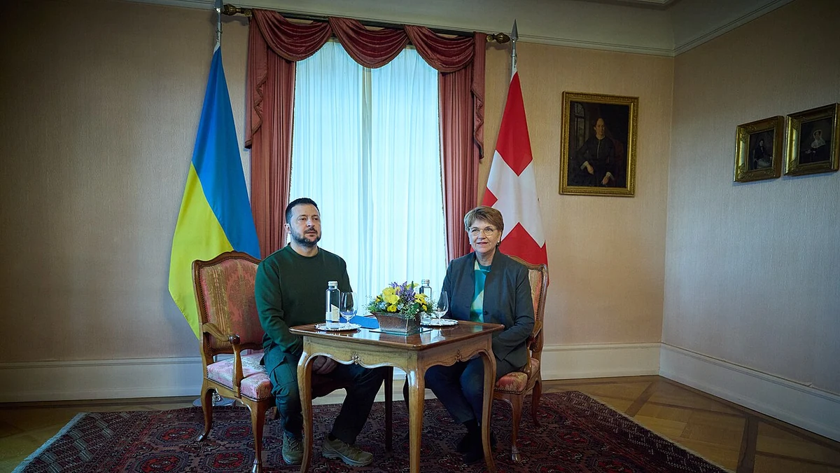 National flags of Ukraine and Switzerland stand behind officials at a meeting in Switzerland.