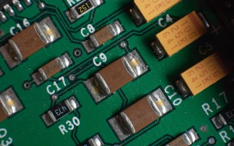 Close-up of multilayer ceramic capacitors and other components mounted on a green printed circuit board.
