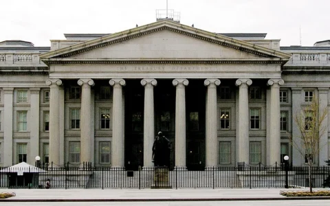 Front facade of the U.S. Treasury Department building in Washington, D.C., with columns and a central statue.