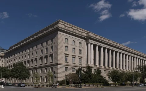 Facade of the Internal Revenue Service building in the Federal Triangle area of Washington, D.C., beneath a blue sky.
