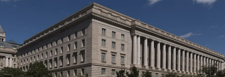 Facade of the Internal Revenue Service building in the Federal Triangle area of Washington, D.C., beneath a blue sky.