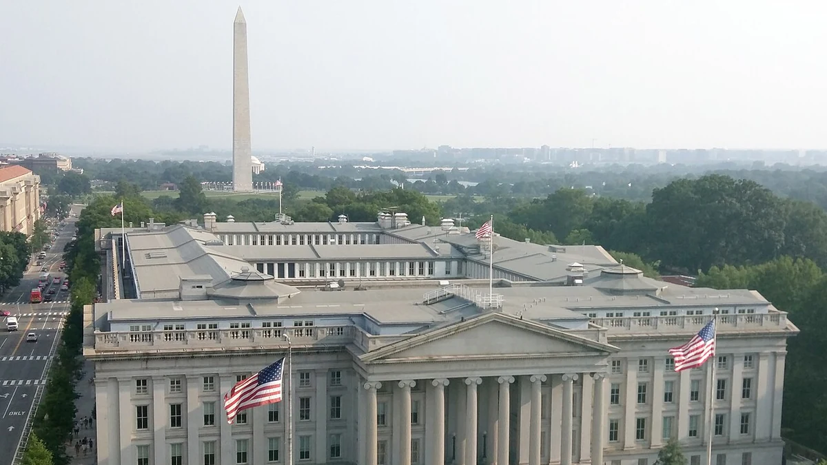 Elevated view of the U.S. Treasury Building in Washington, D.C., with the Washington Monument behind it.