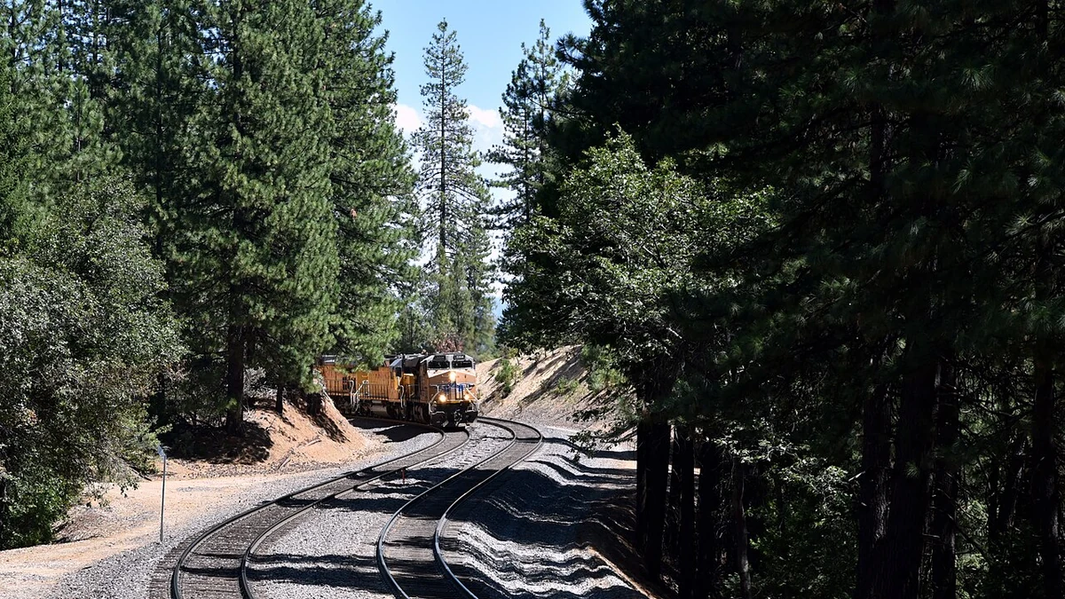 Union Pacific freight locomotives rounding a forested curve in California’s Sierra Nevada mountains.