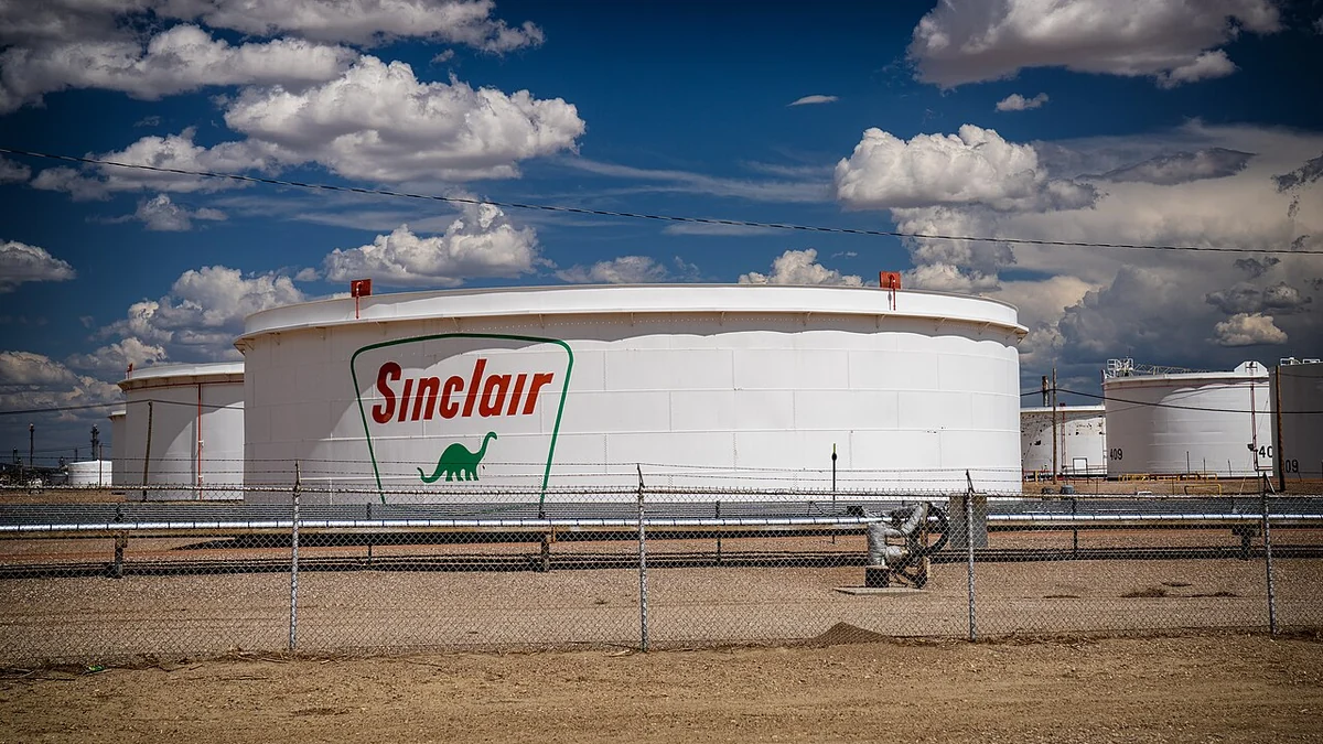 White Sinclair crude oil storage tanks behind a fence at the HF Sinclair refinery in Wyoming.