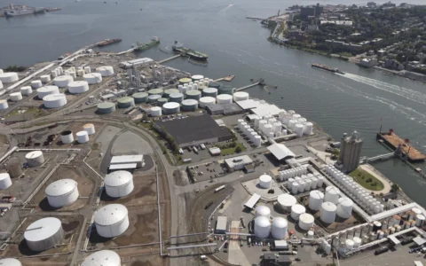 Aerial view of petroleum storage tanks, industrial facilities and ships beside the waterfront in Bayonne, New Jersey.